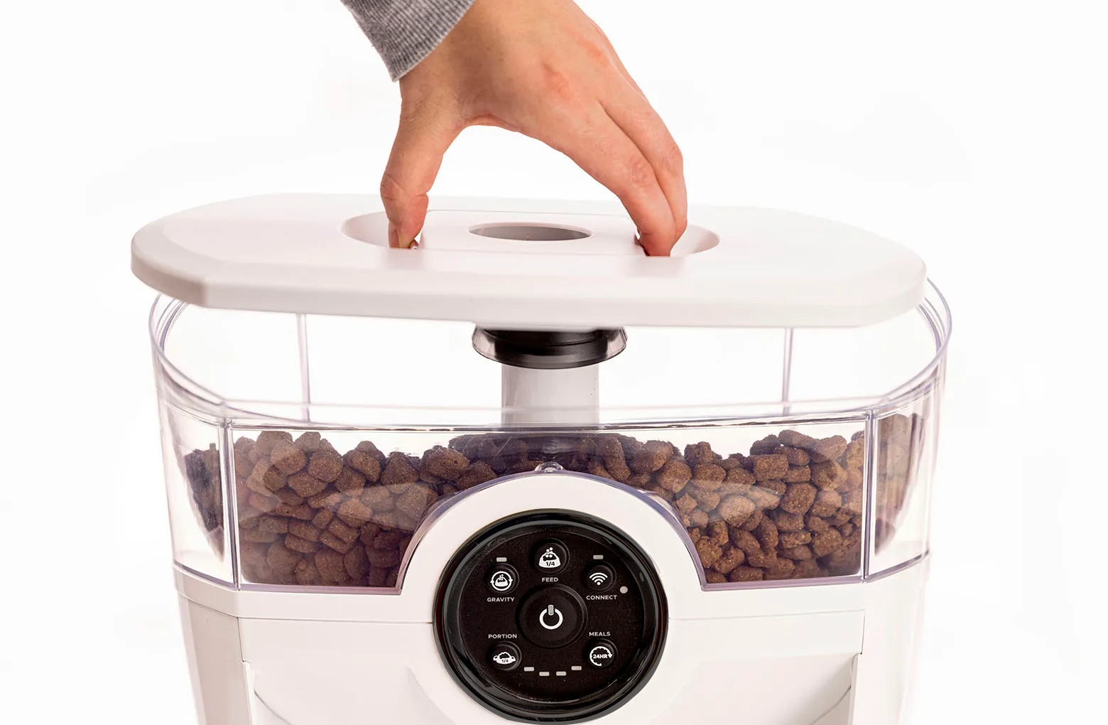 Placing the hopper lid on by squeezing the release in the center of the lid