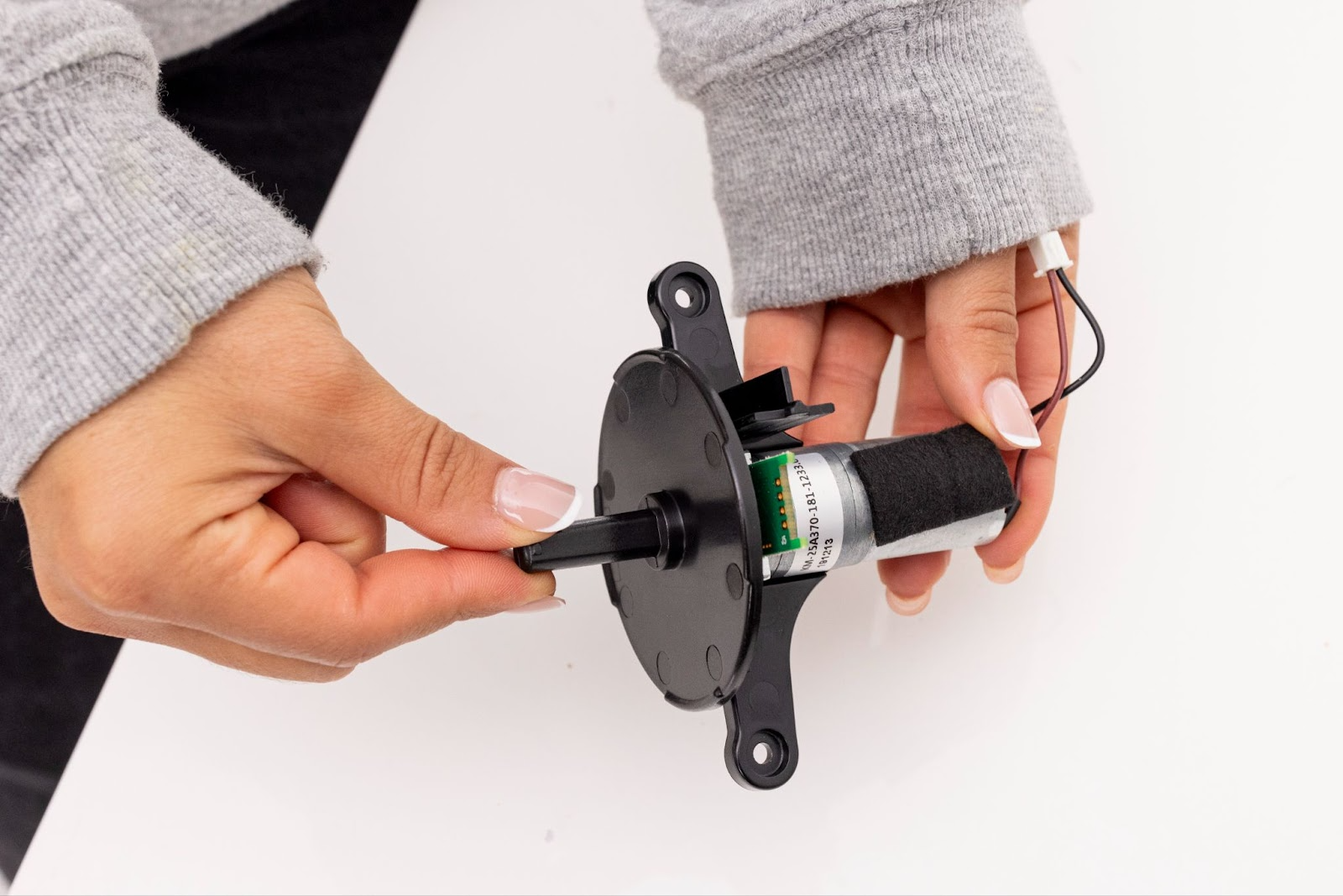 Sliding the black, circular dispenser adapter onto the new motor assembly